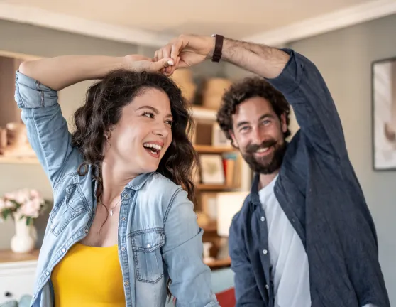 Pareja bailando y riéndose en casa