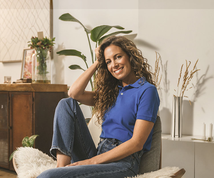 chica sonriente, sentada comodamente en casa